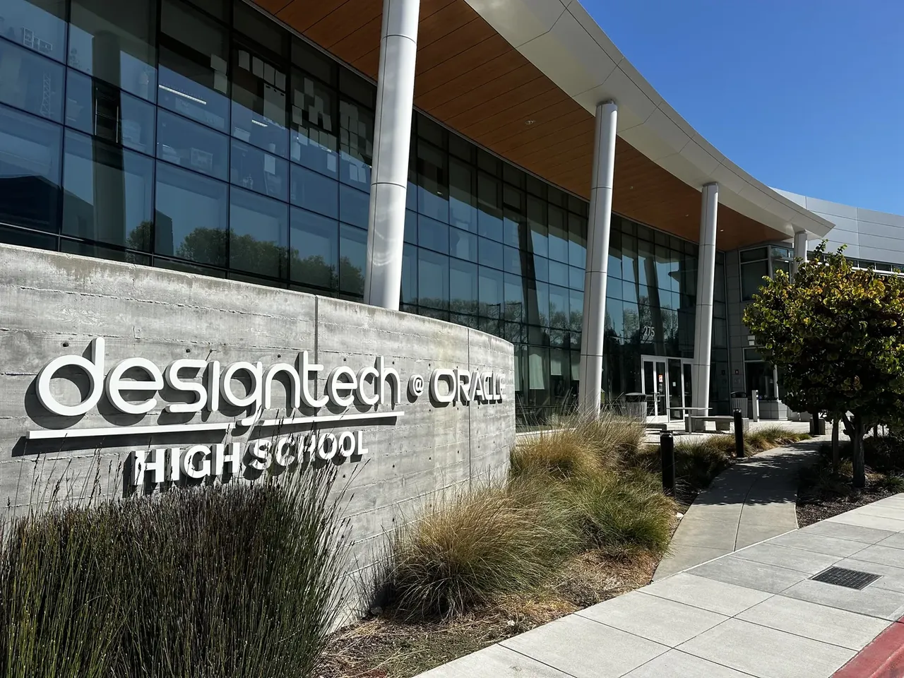The glass campus building with Design Tech High School signage