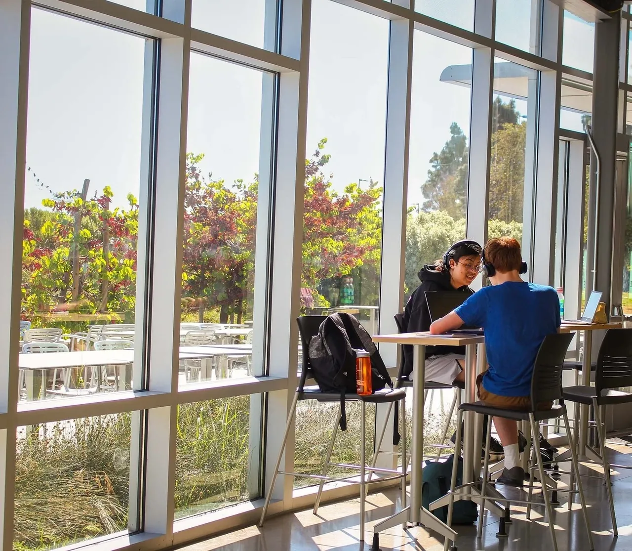 Students in conversation around a table beside the school windows