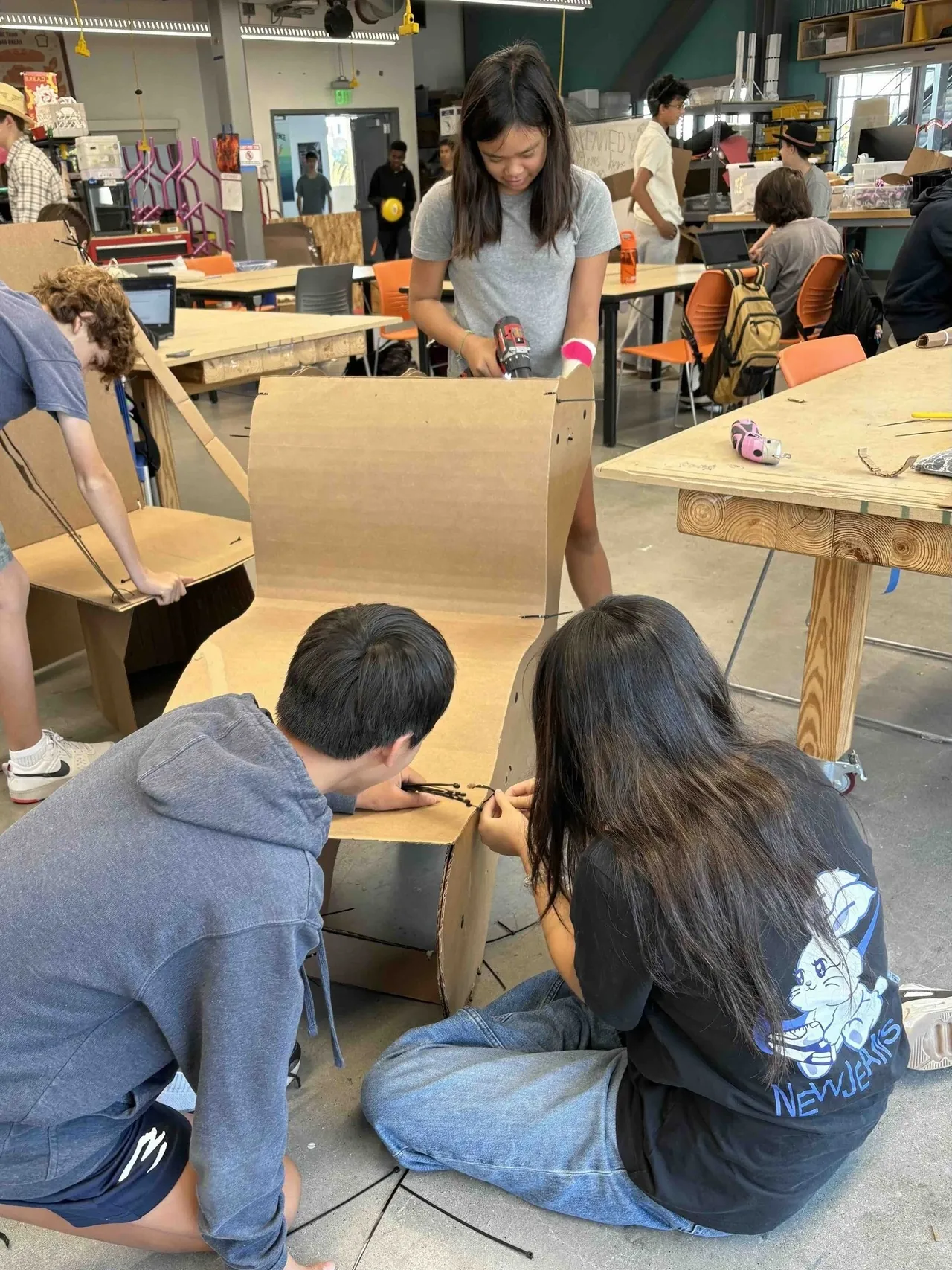 Students working together on a wooden prototype in the makerspace