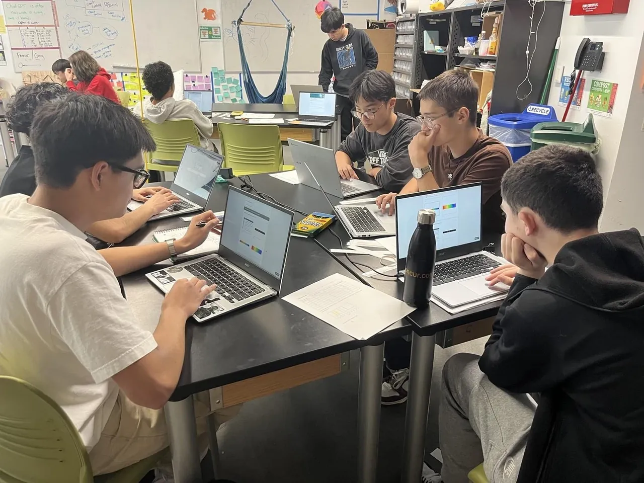 Students working together on laptops in a science classroom