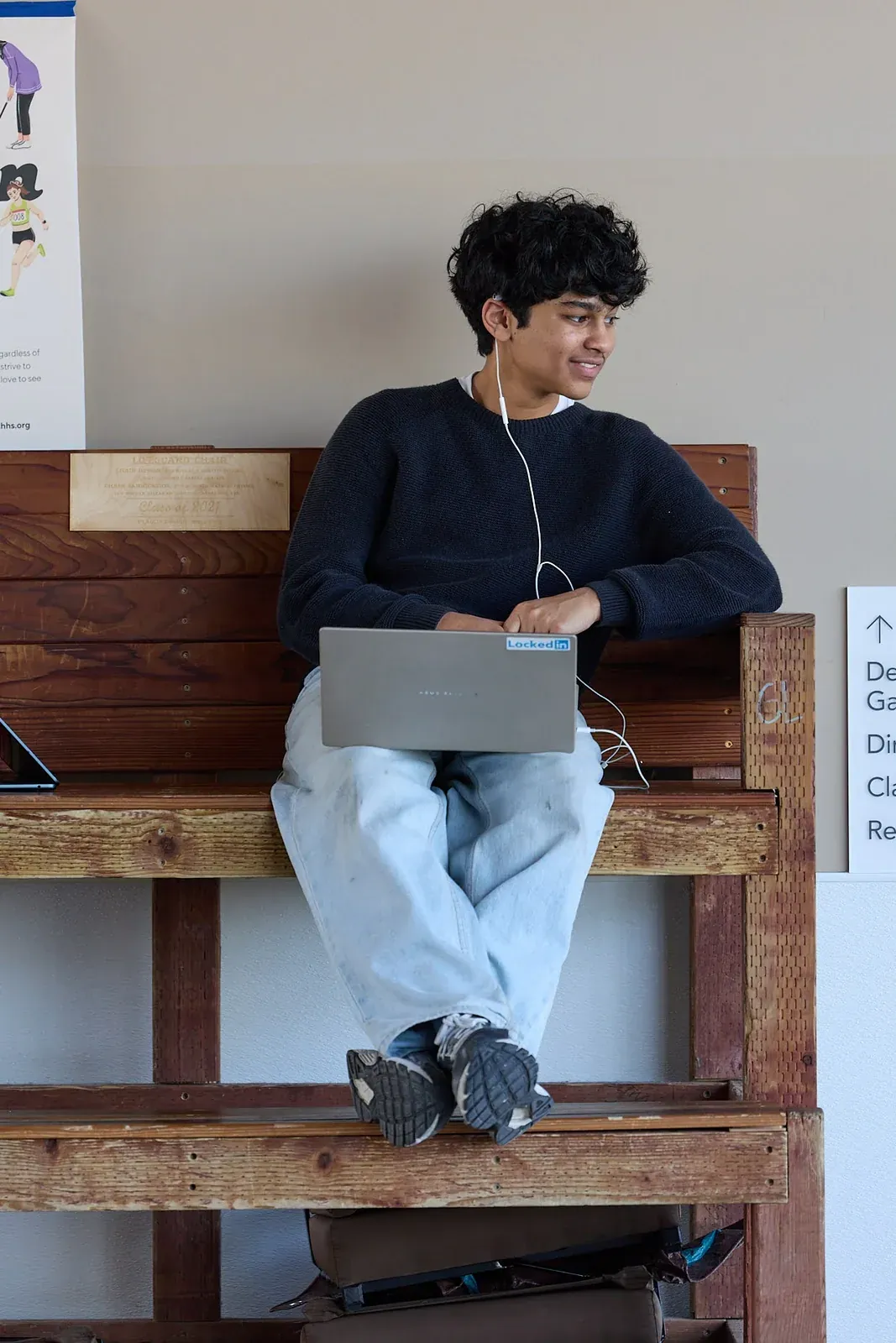 A student working on a laptop beside classroom windows