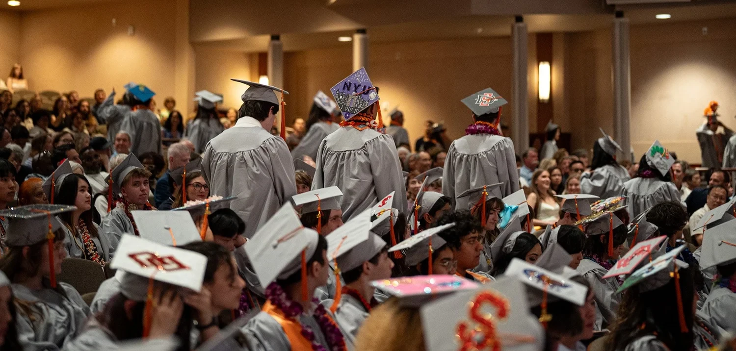 d.tech seniors gather for graduation wearing caps and gowns.